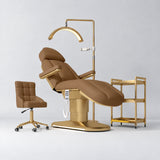 Manufakturo Étoile Caramel complete studio set with electric beauty bed, Noblesse chair, gold trolley and V3 Pro Gold treatment lamp with an aligned stand on the original grey studio background.