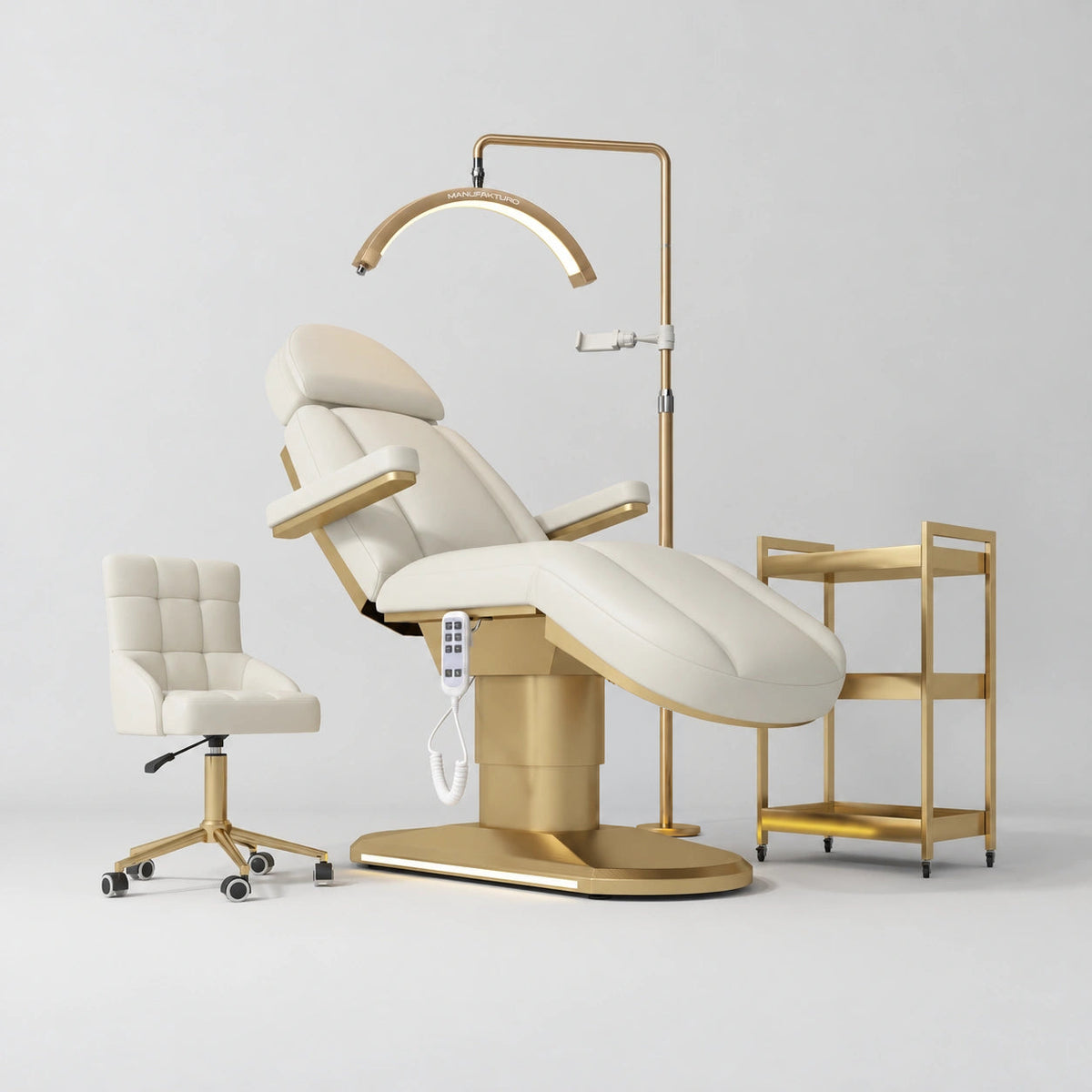 Manufakturo Étoile Creamy complete studio set with electric beauty bed, Noblesse chair, gold trolley and V3 Pro Gold treatment lamp with an aligned stand on the original grey studio background.