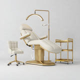 Manufakturo Étoile Creamy complete studio set with electric beauty bed, Noblesse chair, gold trolley and V3 Pro Gold treatment lamp with an aligned stand on the original grey studio background.