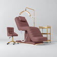 Manufakturo Grandeur Dusty Rose four-piece salon set with treatment bed, matching salon chair, V3 Pro Gold lamp and empty gold three-tier beauty trolley.