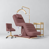 Manufakturo Grandeur Dusty Rose four-piece salon set with treatment bed, matching salon chair, V3 Pro Gold lamp and empty gold three-tier beauty trolley.