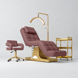 Manufakturo Saphir version A Dusty Rose four-piece salon set with treatment bed, matching salon chair, V3 Pro Gold lamp and empty gold three-tier beauty trolley.