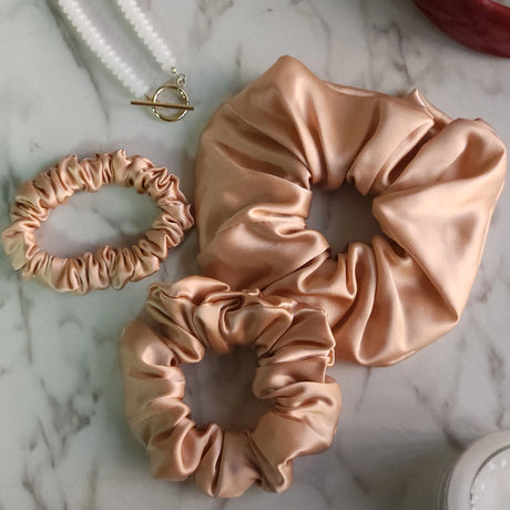 Roxie Cosmetics Luxe 100% Mulberry Silk 30 Momme Scrunchie Beige - product displayed with its packaging on a dark background