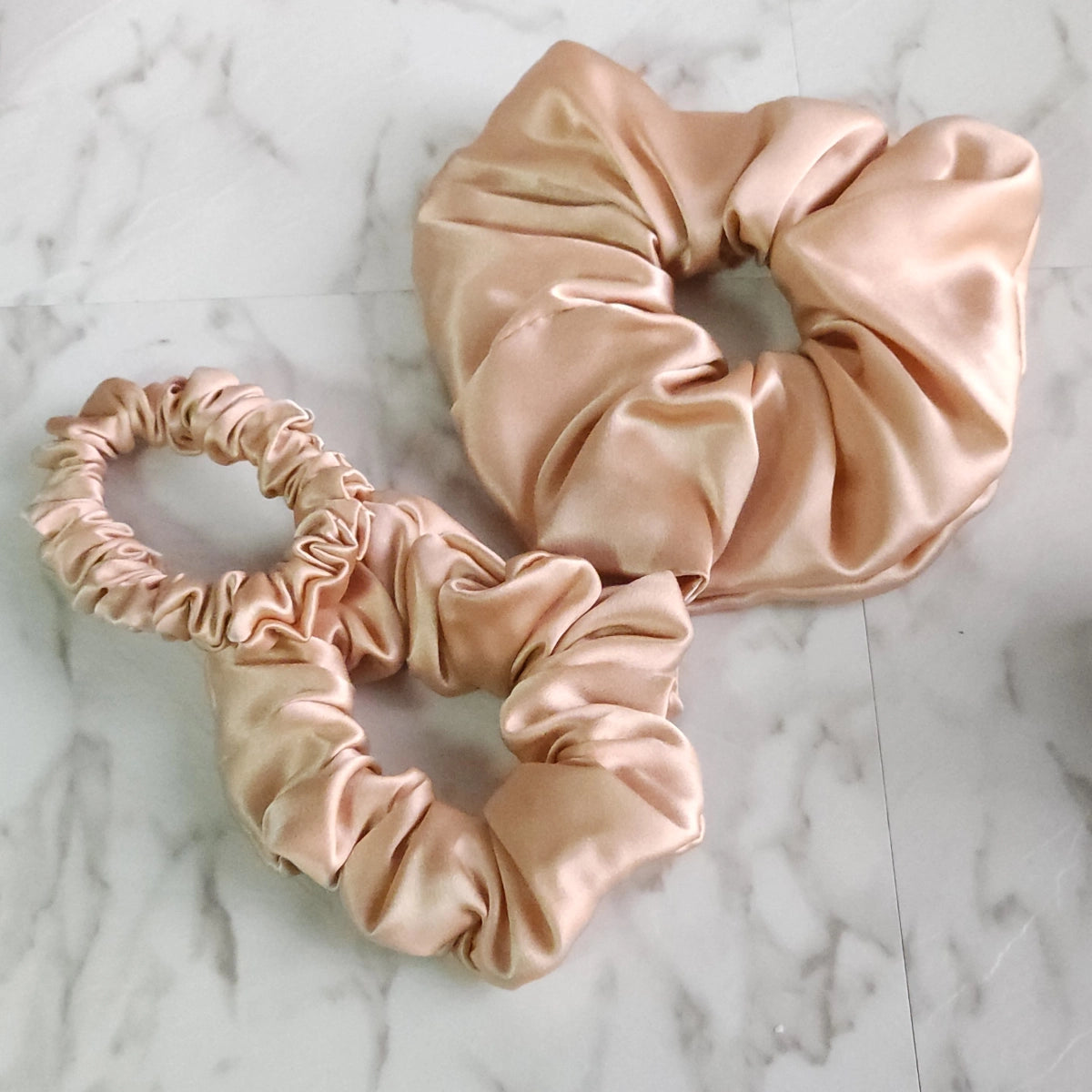 Roxie Cosmetics Luxe 100% Mulberry Silk 30 Momme Scrunchie Beige - product displayed with its packaging on a dark background