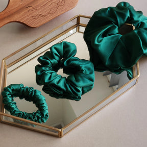 Roxie Cosmetics Luxe 100% Mulberry Silk 30 Momme Scrunchie Bottle Green - product displayed with its packaging on a dark background
