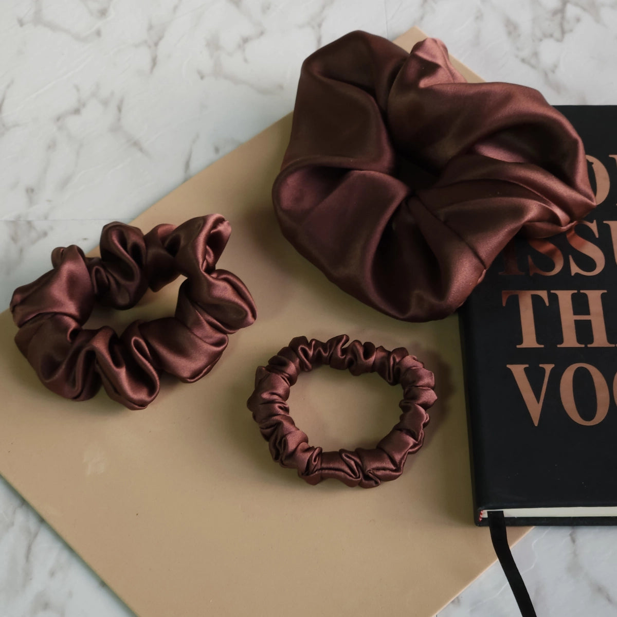 Roxie Cosmetics Luxe 100% Mulberry Silk 30 Momme Scrunchie Chocolate Brown - product displayed with its packaging on a dark background