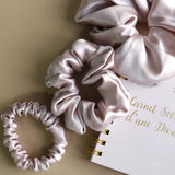 Roxie Cosmetics Luxe 100% Mulberry Silk 30 Momme Scrunchie Powder Pink - product displayed with its packaging on a dark background